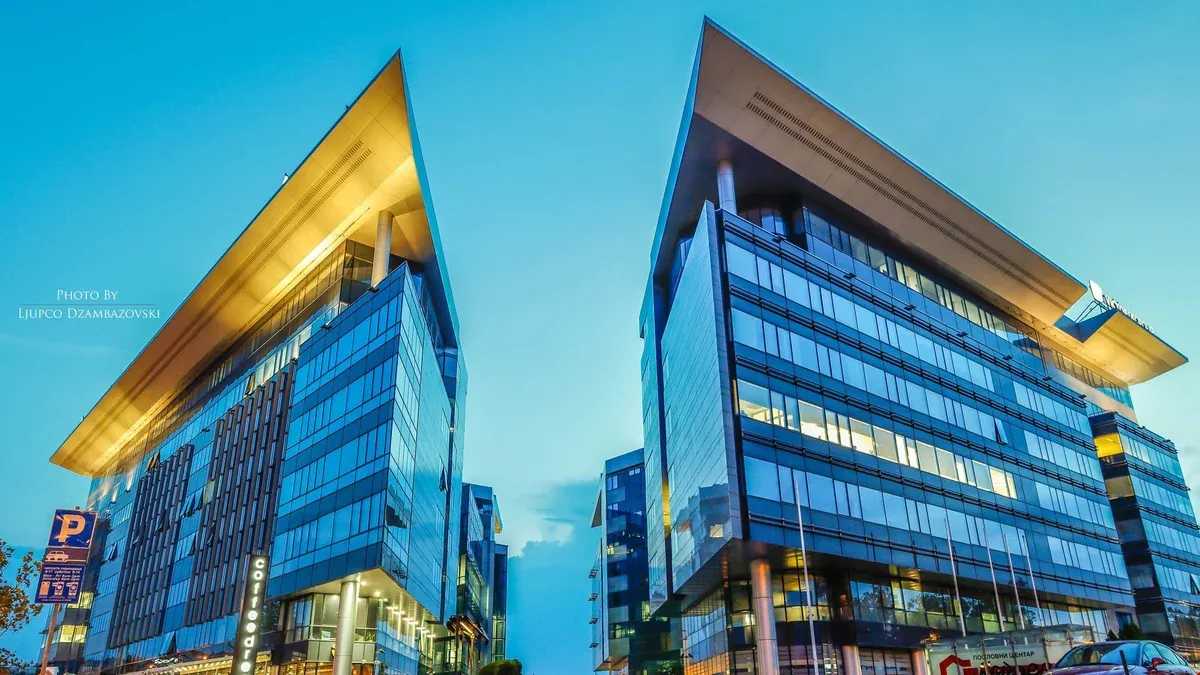Futuristic glass office buildings at sunset in an urban area, conveying modern business architecture.