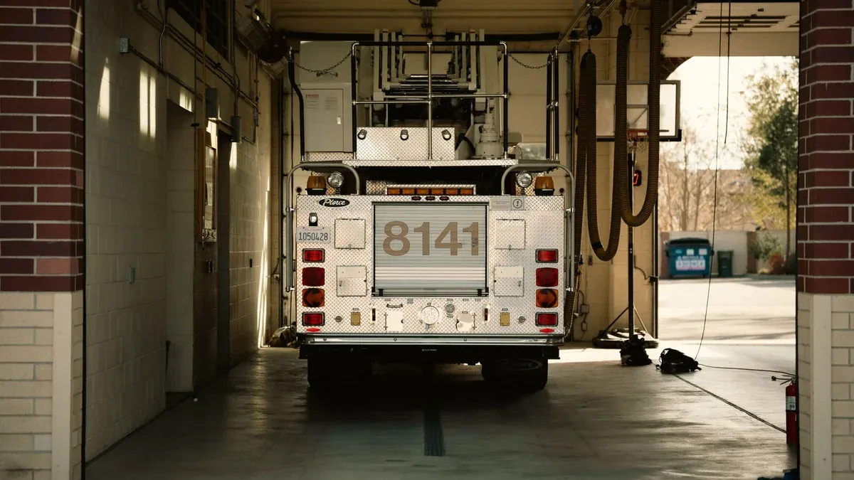A fire truck parked inside a station's garage, showcasing emergency preparedness.