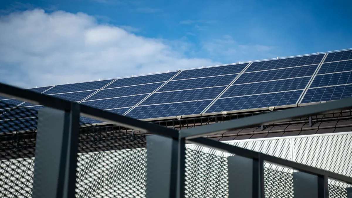 Close-up view of modern solar panels on a rooftop against a clear blue sky, representing clean energy.
