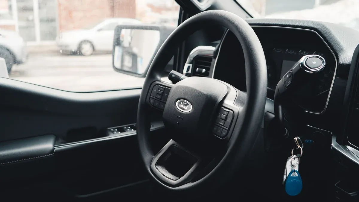 Interior view of a Ford vehicle showing steering wheel, dashboard, and car keys for modern automotive design.
