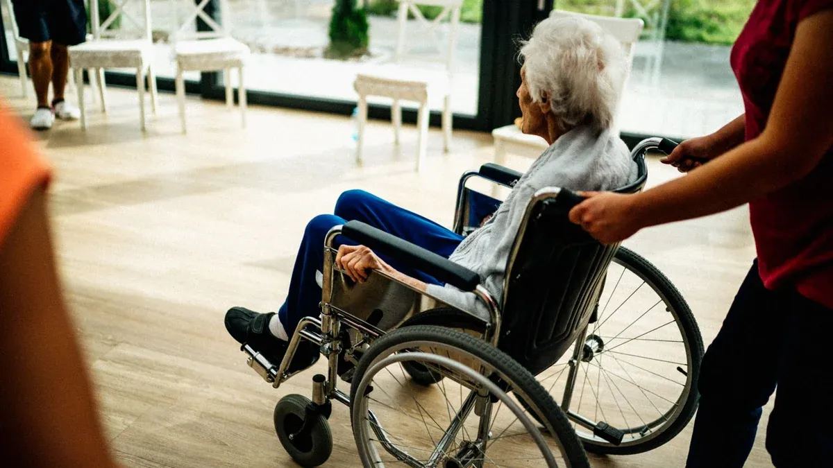A caregiver assists a senior adult in a wheelchair at a nursing home in Prague, Czech Republic.