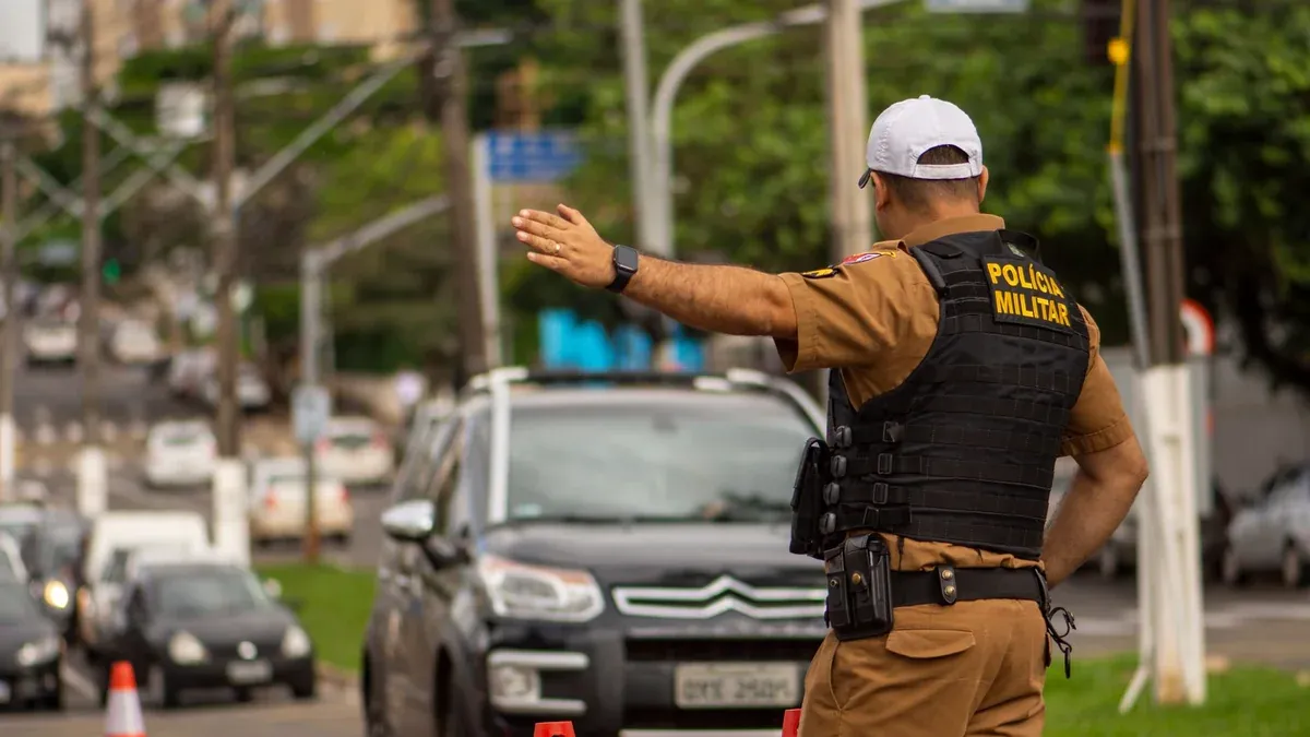 Police officer directing traffic on a busy street in Londrina, Brazil.