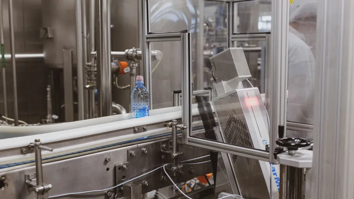 Close-up of a plastic bottle in a modern factory bottling production line.