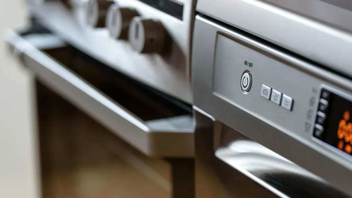 Close-up view of modern stainless steel kitchen appliances with focus on dishwasher and oven.