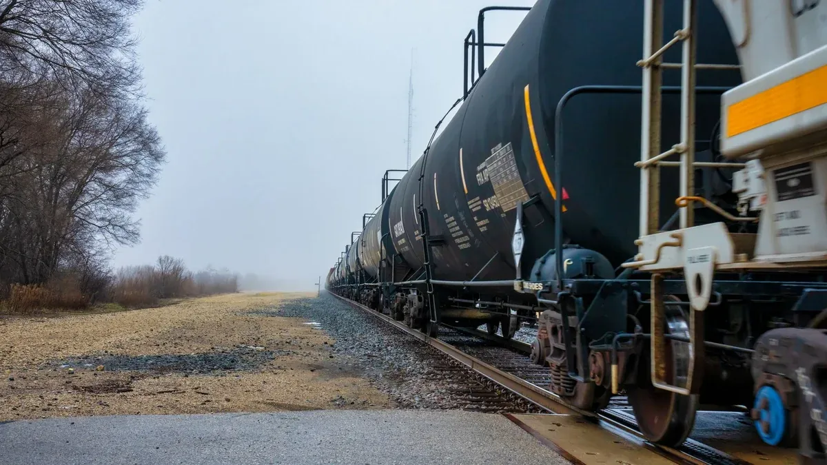 Long freight train with tank cars on tracks in foggy Wabasha, Minnesota