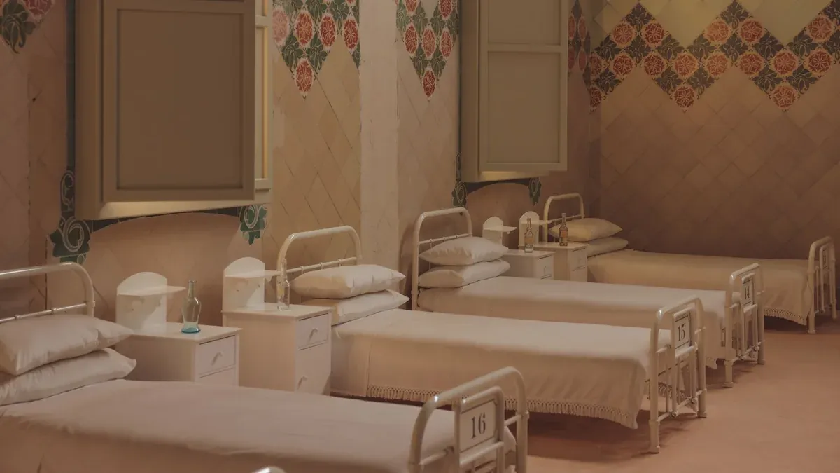 A serene and vintage hospital ward with empty beds in Barcelona.
