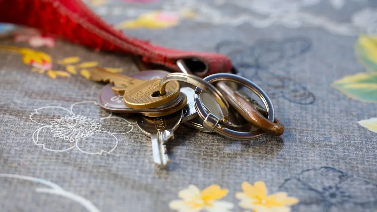 A set of keys lying on a floral-patterned fabric background. Ideal for security themes.