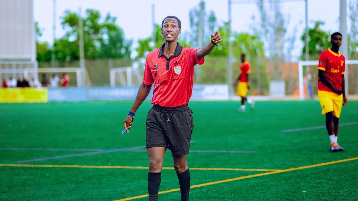 Referee in action during a football match, outdoors on a green field.