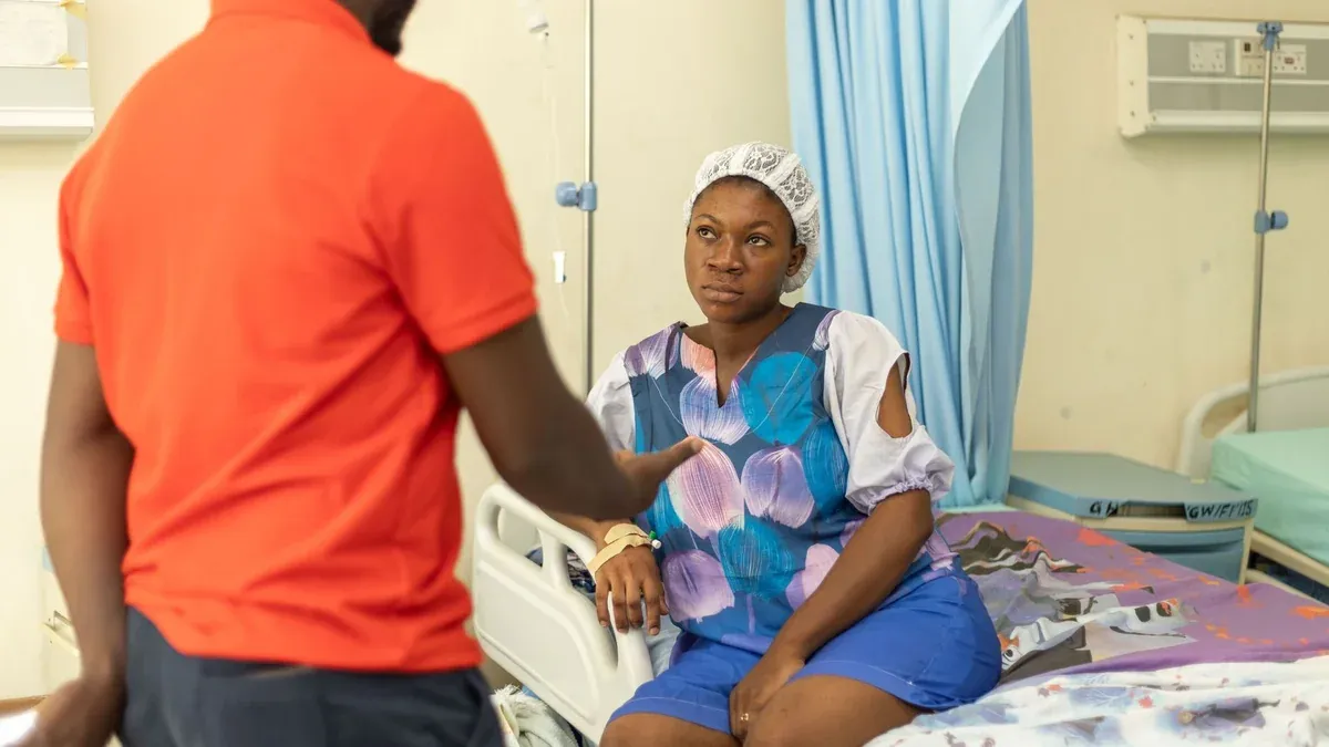 Medical staff talking to a patient in a hospital room, showcasing a healthcare interaction.