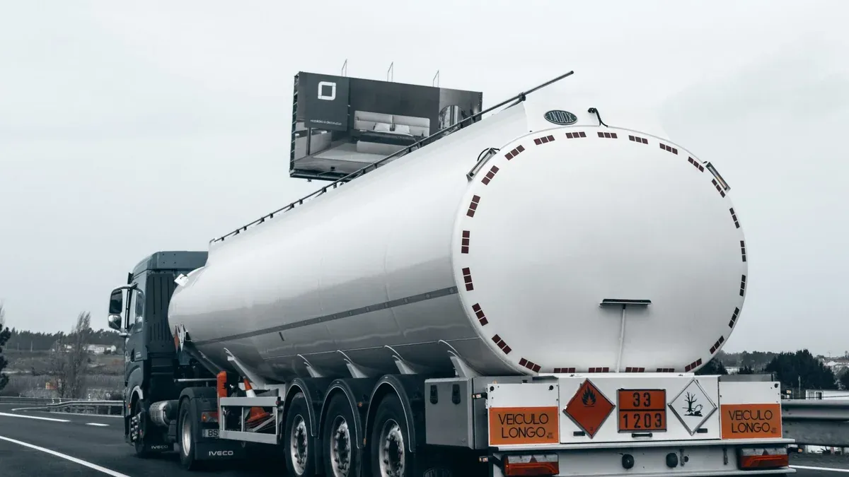 Rear view of a large tanker truck transporting fuel on a highway, emphasizing logistics and transportation.