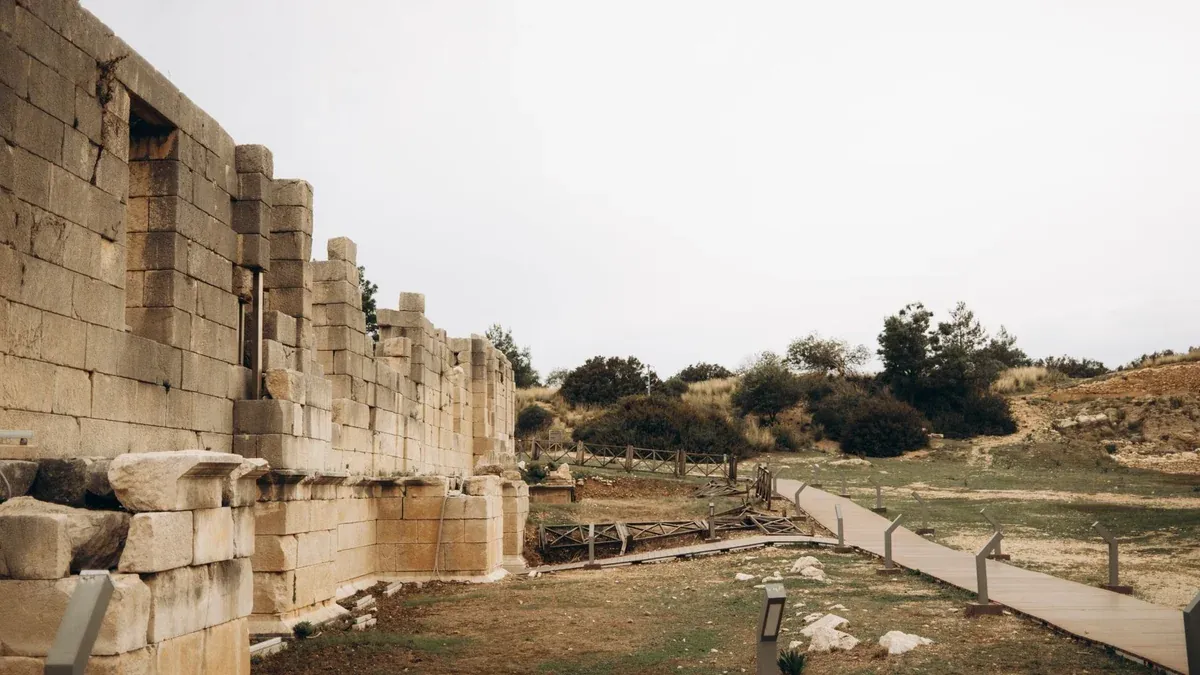 Explore historic ruins with a pathway amidst a serene, natural landscape.