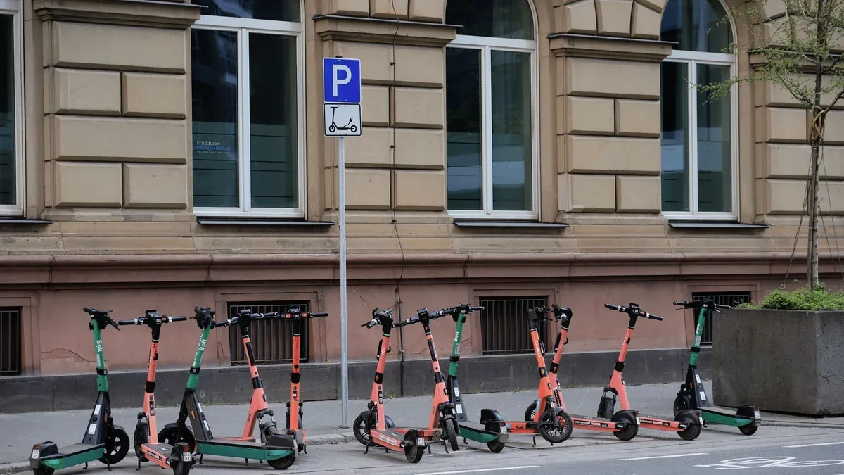 Row of electric scooters parked on a street in downtown Frankfurt, Germany.
