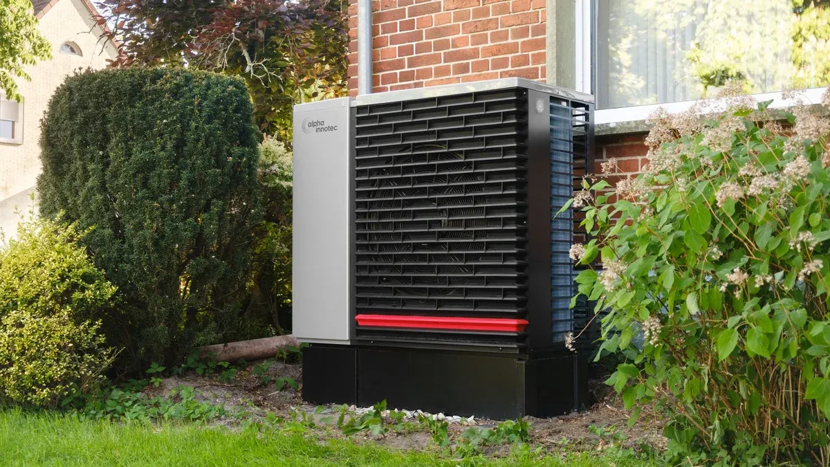 Energy-efficient heat pump in a green residential garden setting.