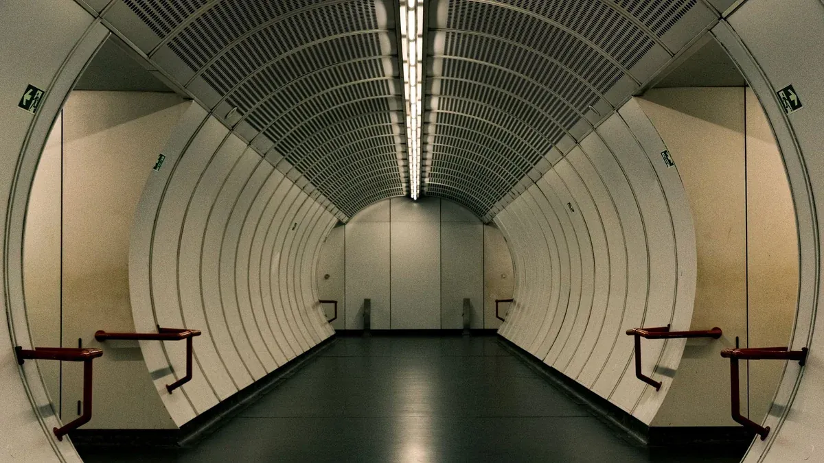 Symmetrical curved corridor in Vienna metro station, showcasing modern transportation architecture.