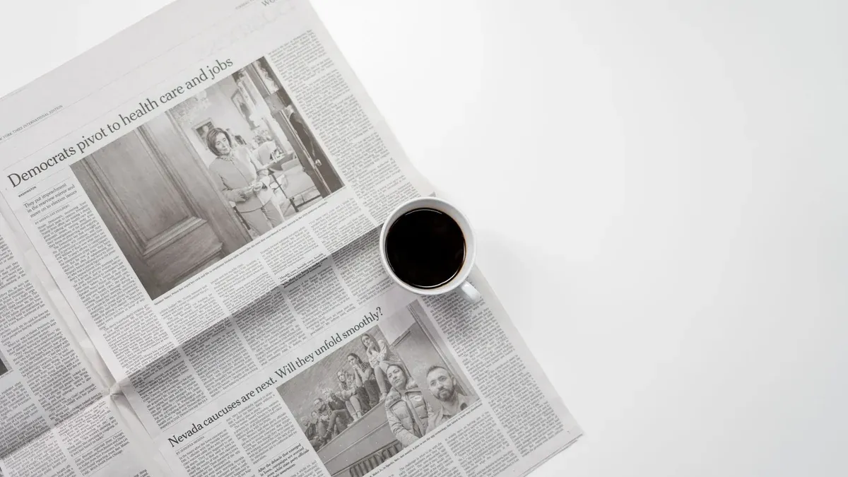 A fresh cup of coffee resting on a newspaper, perfect morning routine setup.