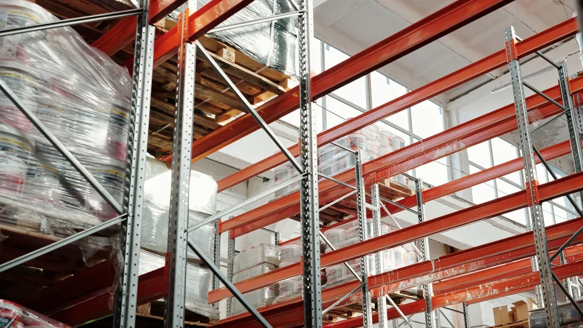 Bright modern warehouse featuring pallets and storage racks for logistics and inventory management.