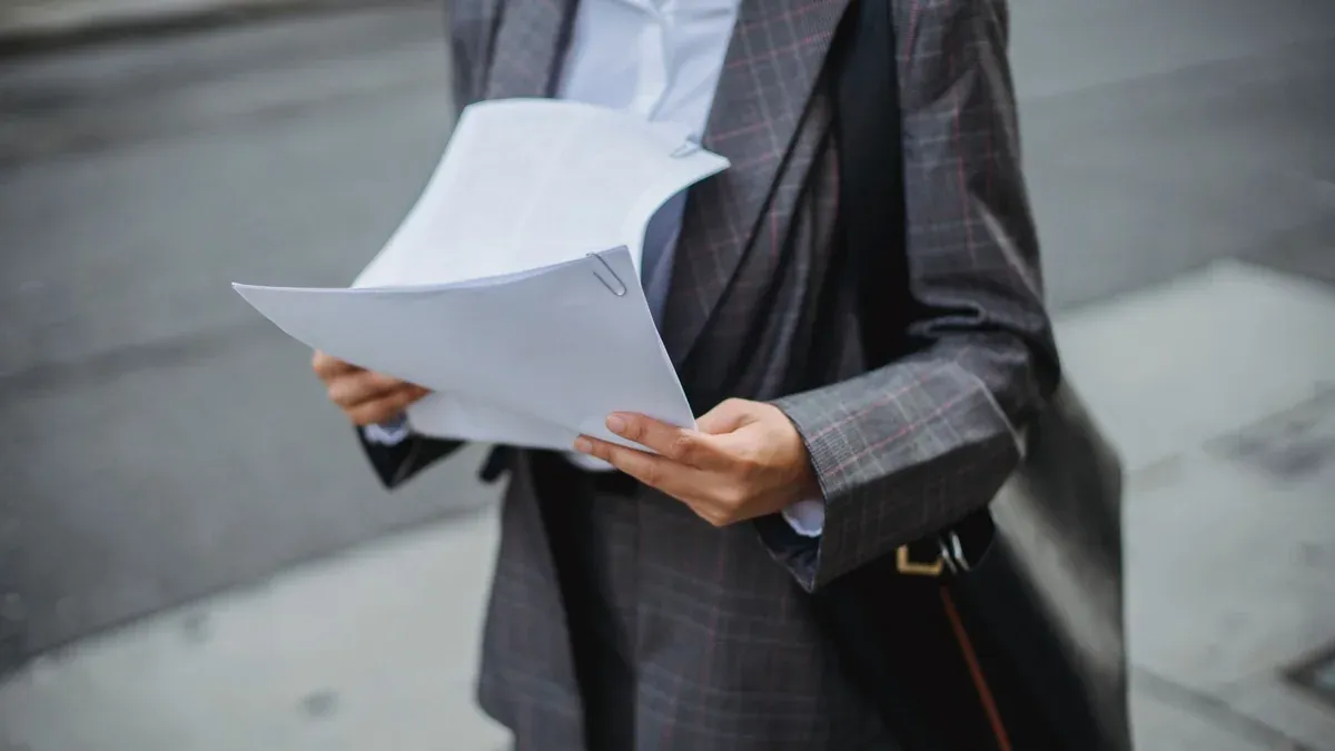 Professional businesswoman reviewing documents outdoors in a city environment.