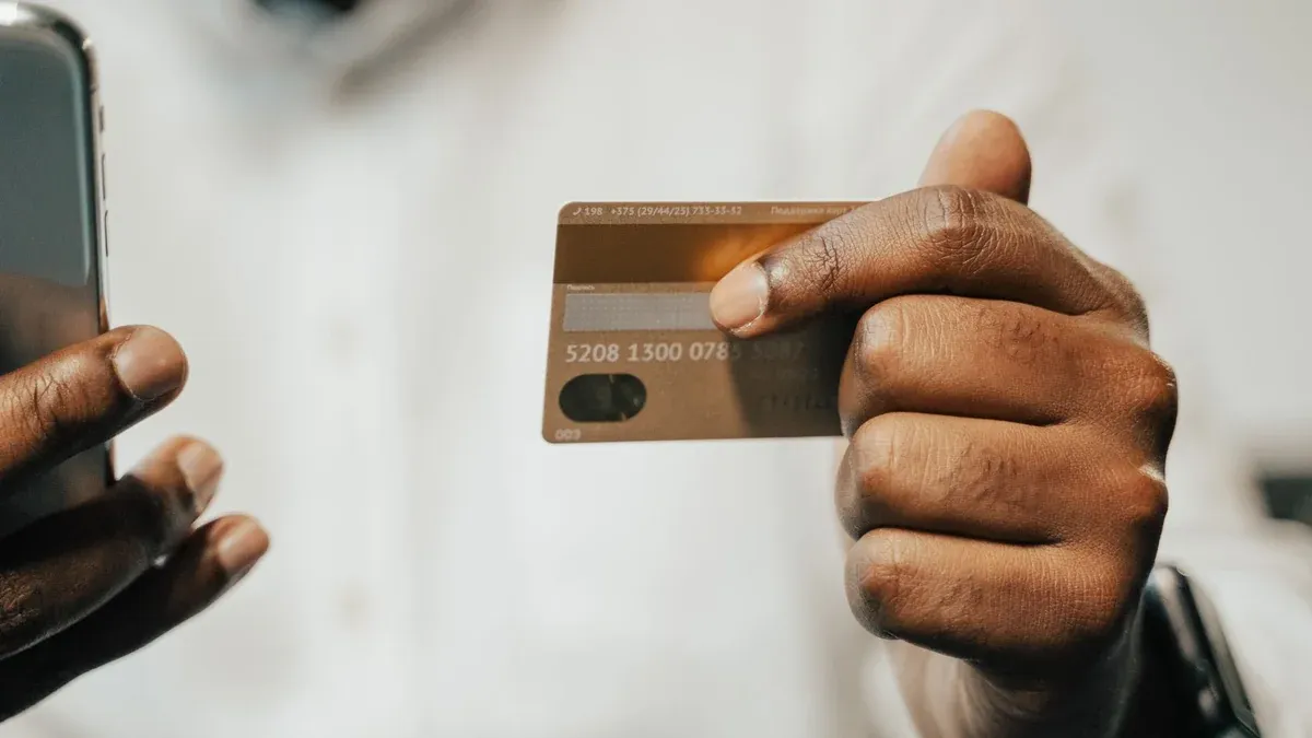 Person using a smartphone and credit card for online shopping or payment.