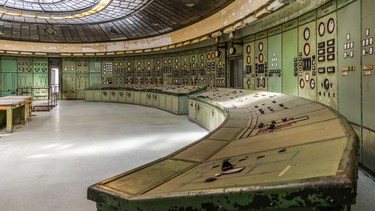 Retro industrial control room with vintage panels and dials in an old power plant.