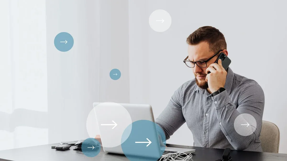 Professional man multitasks with laptop and smartphone in home office environment.