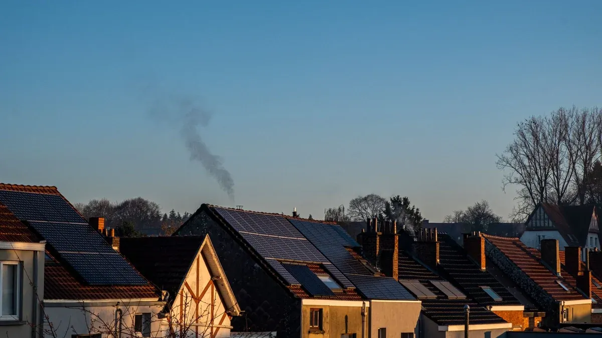 A row of houses displaying solar panels on their rooftops, reflecting sustainable energy practices.