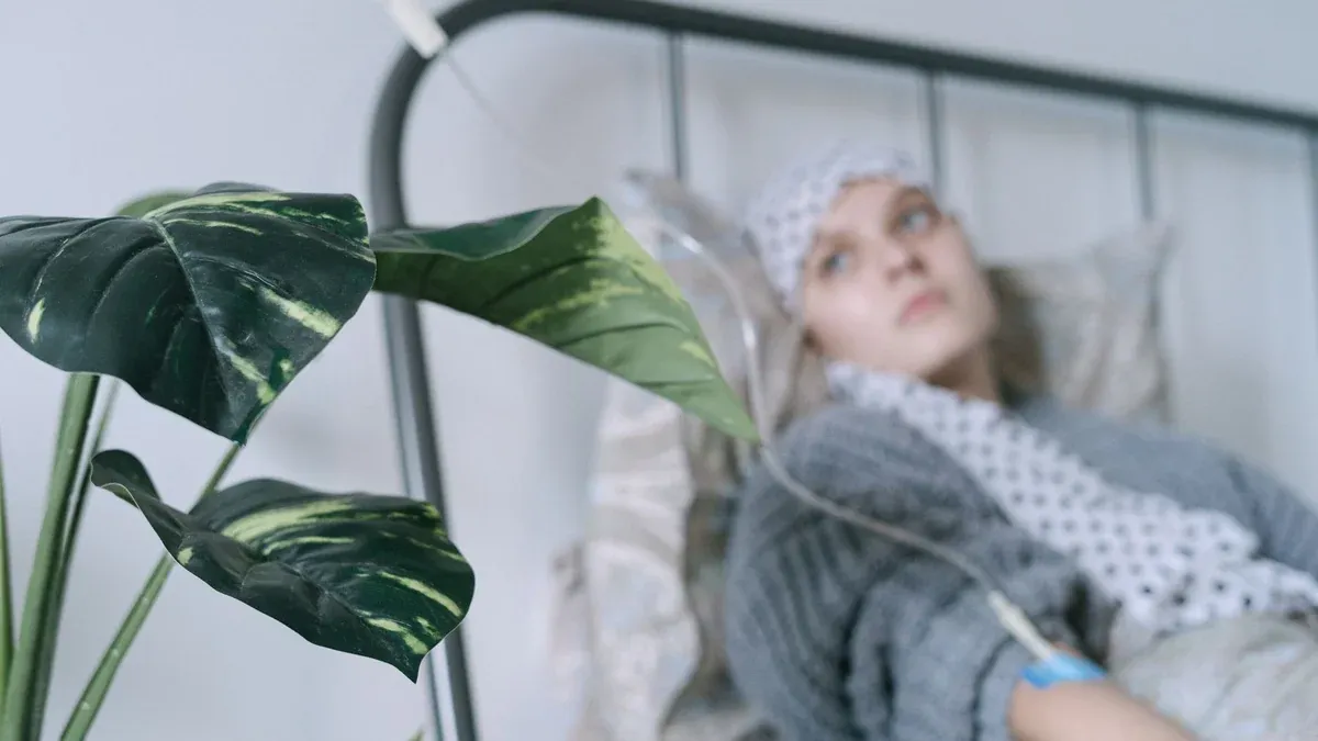 A cancer patient with an IV drip lies on a hospital bed, reflecting hope and recovery.