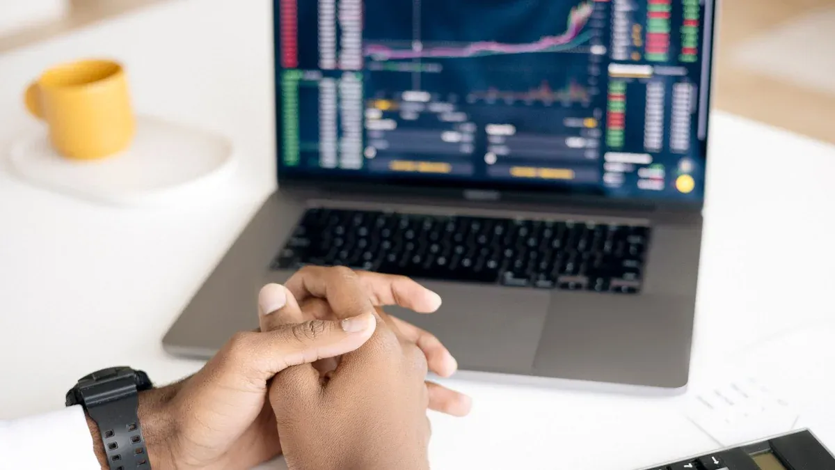 Close-up of a person analyzing stock data on a laptop with graphs and charts visible.