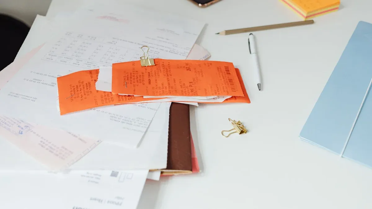 Close-up of a tidy desk with receipts, documents, and office stationery for business organization.
