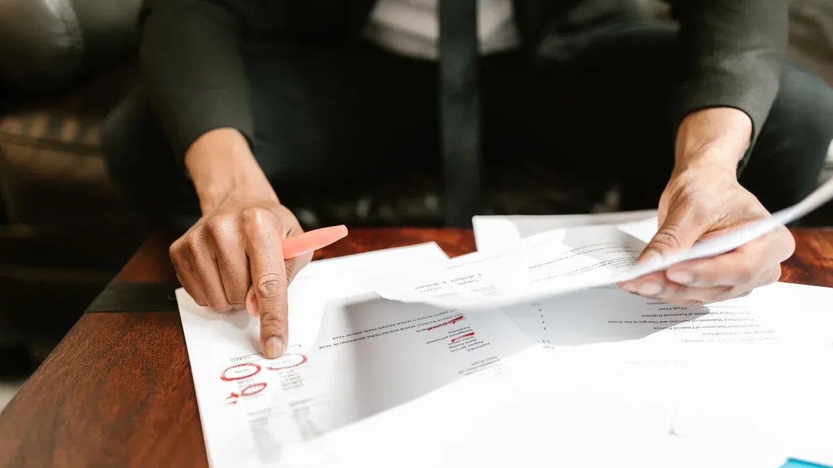 A businessman analyzing financial documents with important data and figures on a desk, ideal for business analytics and accounting themes.