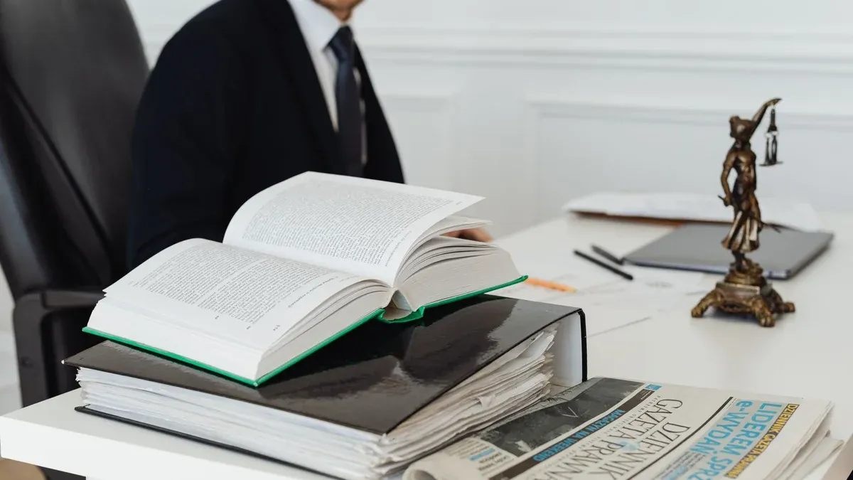 A lawyer sitting at a desk with legal books, documents, and a newspaper, embodying professionalism.