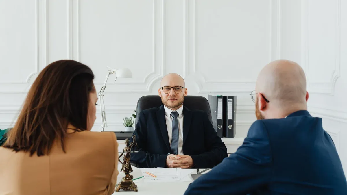 Lawyer meeting with clients in a formal office setting for legal consultation.