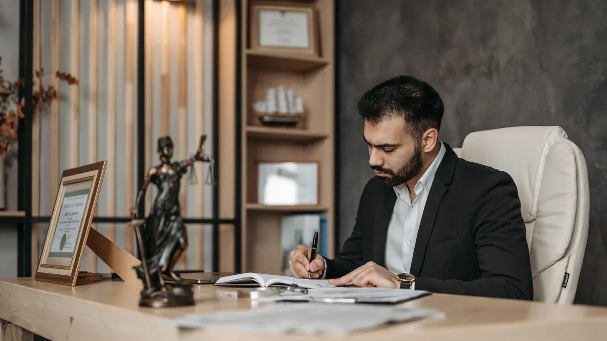 A focused lawyer in an office setting writing and reviewing legal documents, symbolizing expertise and professionalism.