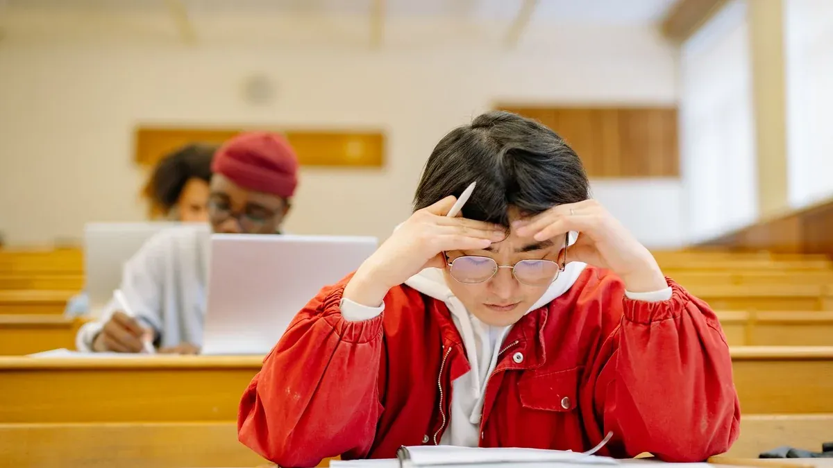 Focused students studying intensely in a university lecture hall setting.