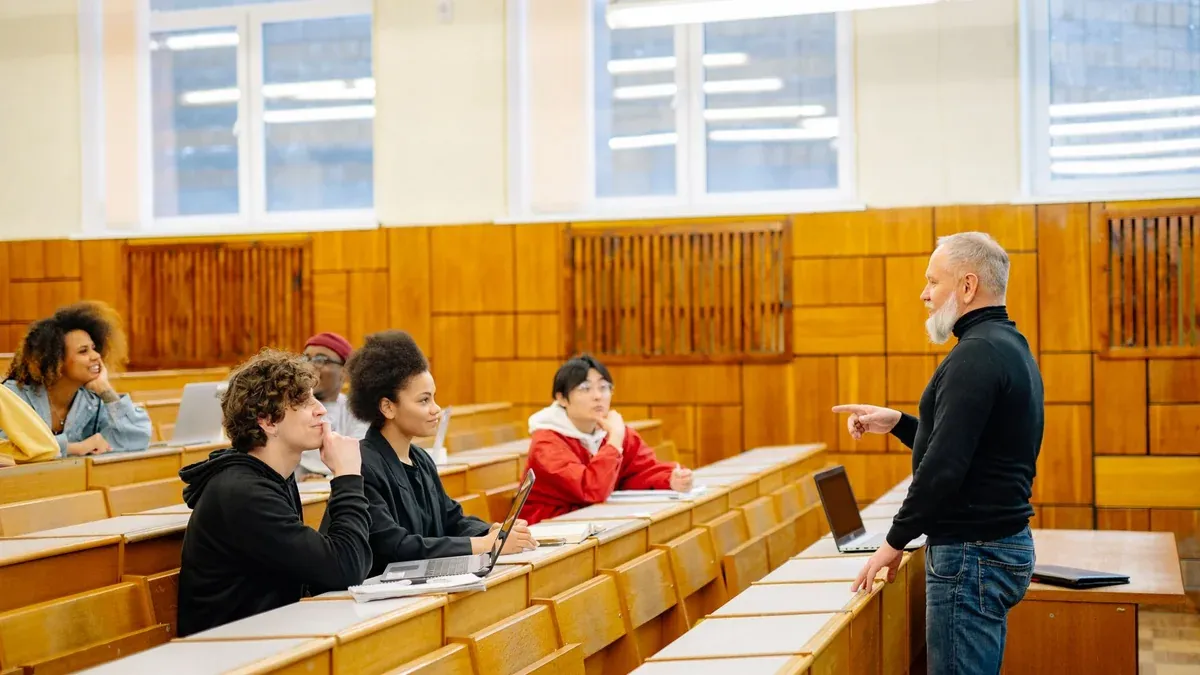 A diverse group of university students engaging with a professor during a classroom lecture.