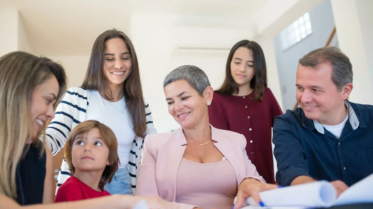 A family gathering around a table, discussing real estate documents indoors with a realtor.
