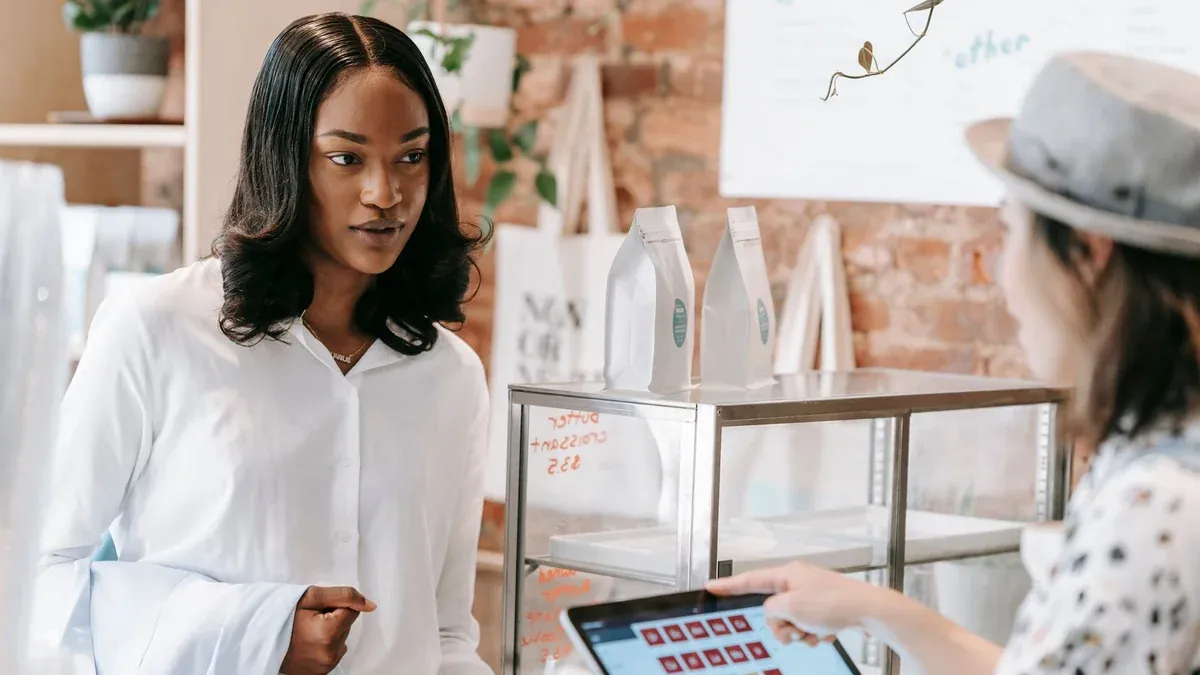 A customer interacts with a barista at a trendy coffee shop counter, showcasing modern retail service.